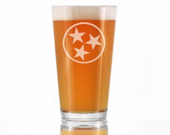Peut inclure: Un verre à bière en verre transparent avec une tête de mousse blanche. Le verre a un cercle blanc avec trois étoiles blanches au centre. Les étoiles sont disposées en forme de triangle.