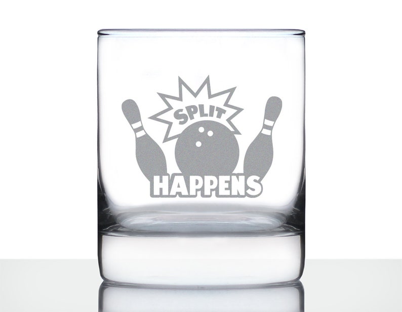 Pode incluir: Um copo de vidro transparente com um desenho gravado em branco de uma bola de boliche e pinos com o texto "SPLIT HAPPENS".