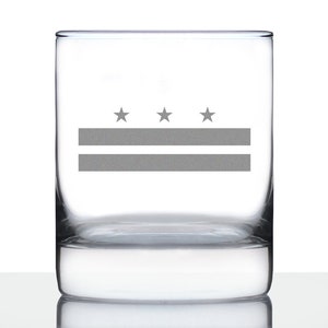 May include: A clear glass tumbler with a gray etched design of the Washington D.C. flag. The flag features three stars and two red stripes.