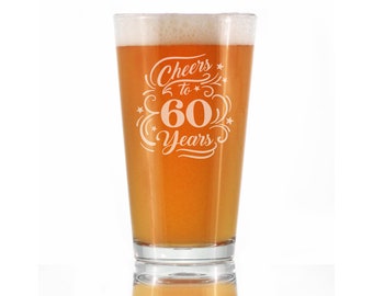 May include: A clear glass pint glass with a white design that says "Cheers to 60 Years". The glass is filled with a light amber colored beer.