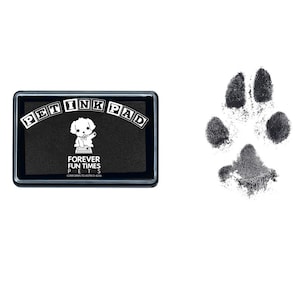 以下が含まれることがあります： 白い文字で「Pet Ink Pad」と書かれた黒いインクパッド。パッドには、漫画の犬と「Forever Fun Times Pets」と「Conforms to ASTM D-4236」の文字が書かれている。インクパッドの右側に黒い足跡が描かれている。