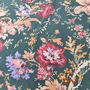 May include: A close-up of a floral pattern on a dark teal background. The design features large, detailed flowers in shades of red, pink, and purple, with accents of yellow and white. The pattern is reminiscent of vintage textiles.