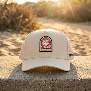 May include: Tan baseball cap with a curved brim and a patch featuring a cartoon character and the words "Runneth Over." The cap has a perforated side panel and the word "Psalm" printed on the side.
