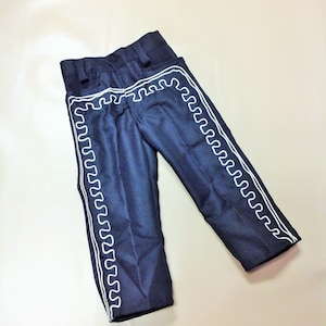Puede incluir: Pantal&oacute;n azul oscuro con ribetes blancos bordados a los lados. El pantal&oacute;n tiene una pierna recta y un ajuste holgado.