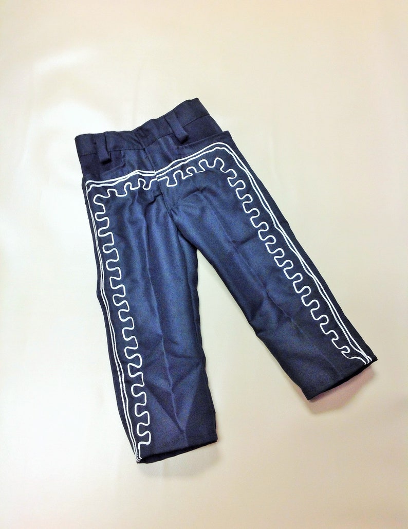 Puede incluir: Pantal&oacute;n azul oscuro con ribetes blancos bordados a los lados. El pantal&oacute;n tiene una pierna recta y un ajuste holgado.