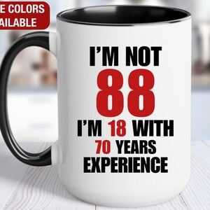 May include: White ceramic mug with a black handle and rim. The mug features the text "I'M NOT 88, I'M 18 WITH 70 YEARS EXPERIENCE" in black and red lettering. The top left corner reads "MORE COLORS AVAILABLE".