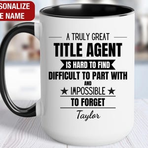 May include: A white coffee mug with a black rim and handle. It has black text that reads "A truly great title agent is hard to find and impossible to forget." The name "Taylor" is printed below the text.