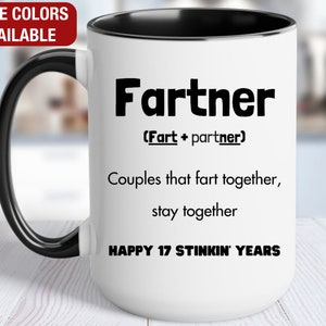 May include: White ceramic coffee mug with a black rim and handle. The mug has black text that reads "Fartner (Fart + partner) Couples that fart together, stay together Happy 17 Stinkin' Years".