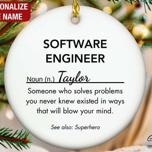 May include: White round ornament with black text that reads "SOFTWARE ENGINEER Noun (n.) Taylor Someone who solves problems you never knew existed in ways that will blow your mind. See also: Superhero"