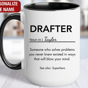 May include: White ceramic mug with a black handle and rim. The mug has a black and white design that reads "DRAFTER Noun (n.) Taylor Someone who solves problems you never knew existed in ways that will blow your mind. See also: Superhero"