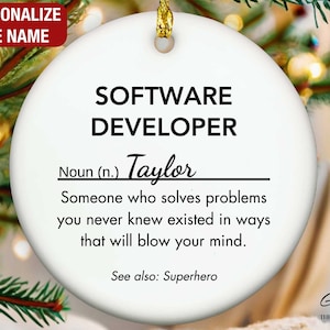 May include: A white ceramic Christmas ornament with gold hanging string. The ornament has the text "SOFTWARE DEVELOPER" and "Taylor" with a definition. The top left corner has the text "PERSONALIZE THE NAME".