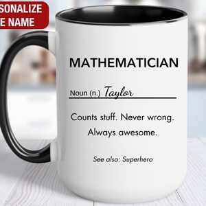 May include: White ceramic mug with a black rim and handle. The mug has black text that reads "MATHEMATICIAN" and "Noun (n.) Taylor" with a line underneath. The text continues with "Counts stuff. Never wrong. Always awesome. See also: Superhero."