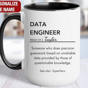 May include: White ceramic mug with a black handle and rim. The mug features the text "DATA ENGINEER" with a definition and the name "Taylor". The mug also includes the text "See also: Superhero".