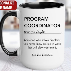 May include: White ceramic mug with a black rim and handle. The mug features a definition of "Program Coordinator" with the name "Taylor" included. The text reads: "Program Coordinator Noun (n.) Taylor Someone who solves problems you never knew existed in ways that will blow your mind. See also: Superhero"