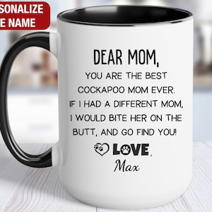 May include: A white ceramic mug with a black handle and the text "But First, Coffee" in a black, bold font. The mug is sitting on a wooden surface. The mug is 4 inches tall.