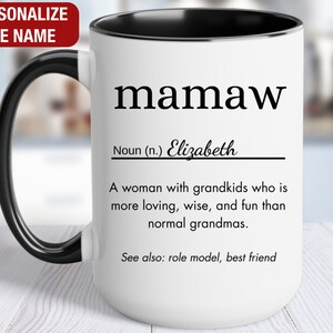 May include: White ceramic mug with a black handle and rim. The mug has a black and white design that reads "mamaw" with a definition and the name "Elizabeth".