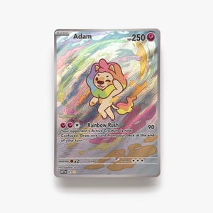 May include: A holographic trading card featuring a cartoon lion with a rainbow mane and tail. The card is labeled "Adam" with "HP 250" and includes the "Rainbow Rush" attack. The background has colorful swirls and streaks.