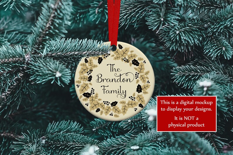 K&ouml;nnte beinhalten: Ein runder Weihnachtsschmuck mit rotem Band, mit dem Text "The Brandon Family", umgeben von einem Kranz aus goldenen Bl&auml;ttern und schwarzen Beeren. Der Schmuck h&auml;ngt vor gr&uuml;nem Tannennadel-Hintergrund.