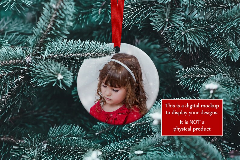 K&ouml;nnte beinhalten: Ein runder Weihnachtsschmuck mit einem Foto eines Kindes, das an einem roten Band h&auml;ngt. Der Schmuck befindet sich vor dem Hintergrund eines Weihnachtsbaums. Der Text auf dem Bild lautet: "Dies ist ein digitales Mockup, um Ihre Designs anzuzeigen. Es ist KEIN physisches Produkt."