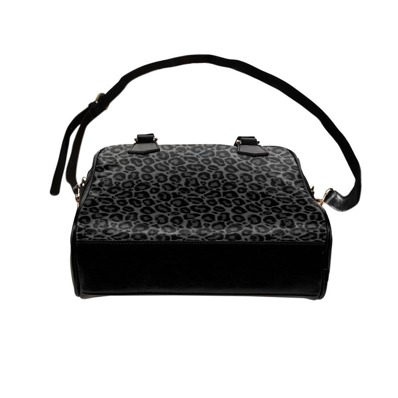 May include: A black handbag with a grey leopard print design. The bag has a top handle and a shoulder strap.