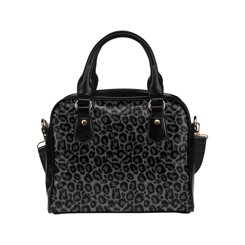 May include: A black handbag with a grey leopard print design. The bag has a top handle and a shoulder strap.