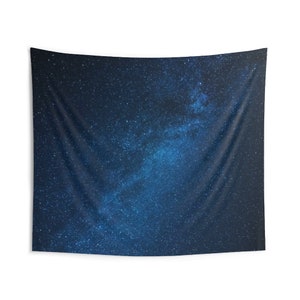 May include: A dark blue tapestry with a white and blue starry night sky design. The tapestry features a large, bright band of stars across the center, resembling the Milky Way.