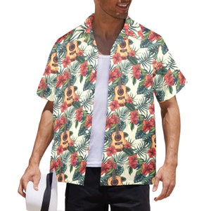 Puede incluir: Una camisa de manga corta con botones y estampado tropical con guitarras, flores y hojas de palma. La camisa es de color crema con detalles rojos, verdes y marrones.