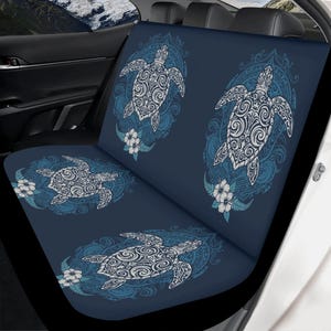 Può includere: Coprisedile per auto blu scuro con un motivo ripetuto di tartarughe marine bianche e blu. Ogni tartaruga è racchiusa in una cornice ovale decorativa con accenti floreali. Il design è stampato su uno sfondo blu scuro.