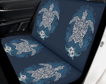 May include: Dark blue car seat cover featuring a repeating pattern of white and blue sea turtles. Each turtle is surrounded by a decorative oval frame with floral accents. The design is printed on a dark blue background.