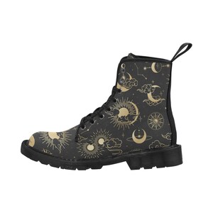 Puede incluir: Bota de combate negra con un dise&ntilde;o celestial dorado de soles, lunas, nubes y estrellas. La bota tiene cierre de cordones, una leng&uuml;eta y una suela negra. El patr&oacute;n se repite en toda la superficie de la bota.