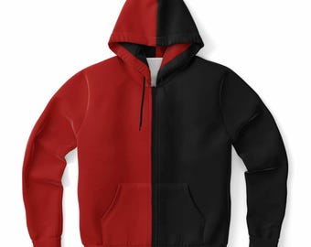 Può includere: Una felpa con cappuccio bicolore con zip. Il lato sinistro è rosso e il lato destro è nero. La felpa con cappuccio ha un cappuccio bicolore abbinato, una tasca frontale sul lato nero e una cerniera a tutta lunghezza. L'indumento è realizzato in materiale morbido.