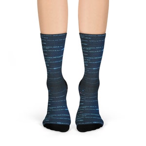 以下が含まれることがあります： 青と白のコードパターンが施された黒いソックスのペア。ソックスは柔らかく快適な素材で作られており、毎日の着用に最適です。