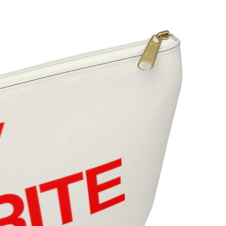 May include: A white canvas zippered pouch with the word "WRITE" in red letters.