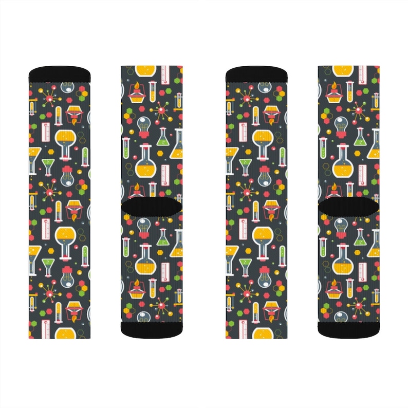 May include: Four pairs of black socks with a colorful science themed pattern. The pattern includes beakers, test tubes, thermometers, and other science equipment.