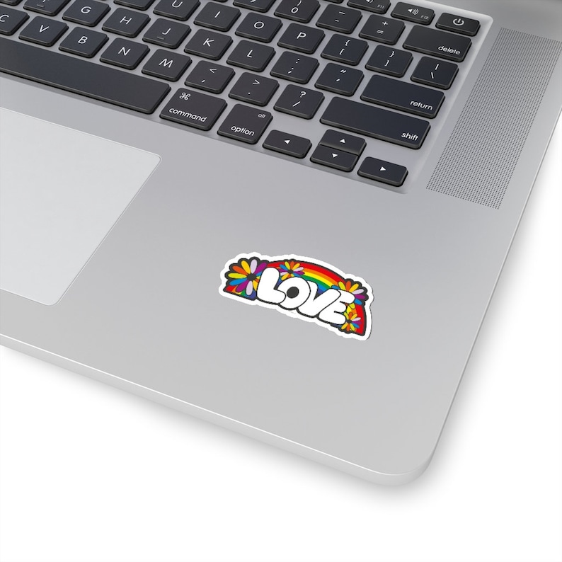 May include: A sticker with a rainbow and flowers surrounding the word "LOVE" in white letters with a black outline.
