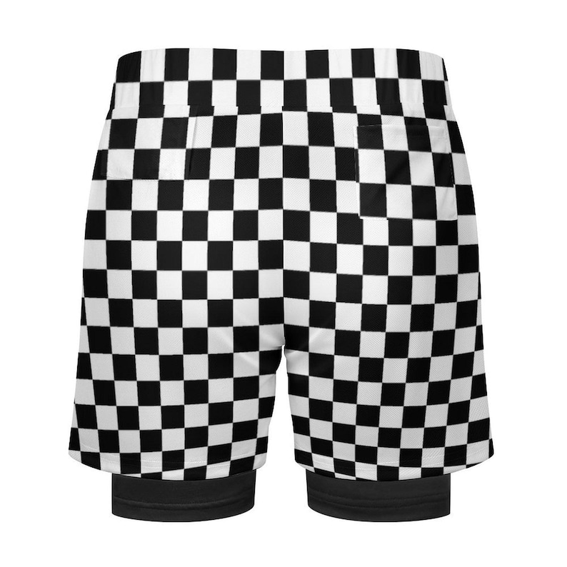 K&ouml;nnte beinhalten: Schwarz-wei&szlig; karierte Sporthosen mit integrierter schwarzer Kompressionsschicht. Die Shorts haben ein klassisches Schachbrettmuster und einen breiten elastischen Bund. Das Design ist sportlich und f&uuml;r verschiedene Aktivit&auml;ten geeignet.