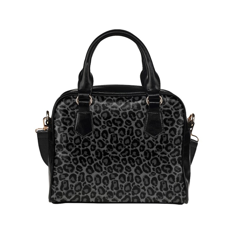 May include: A black handbag with a grey leopard print design. The bag has a top handle and a shoulder strap.
