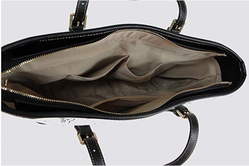 May include: Black leather tote bag with a zipper closure and a beige fabric lining. The bag has two interior pockets and two top handles.