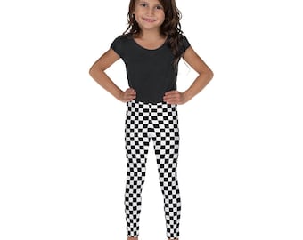 May include: A young person wearing black and white checkered leggings. The leggings have a checkered pattern.