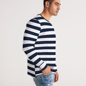 Op de afbeelding: Een shirt met lange mouwen met witte en donkerblauwe horizontale strepen. Het shirt heeft een ronde hals en is gemaakt van een zachte, comfortabele stof.