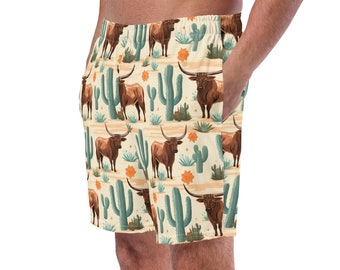 May include: Beige men's swim trunks with a pattern of brown longhorn cattle and green cacti.