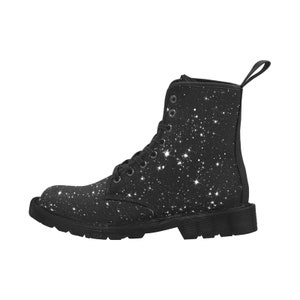 Puede incluir: Botas negras de lona con estampado de cielo estrellado blanco. Las botas tienen cierre de cordones y suela gruesa.