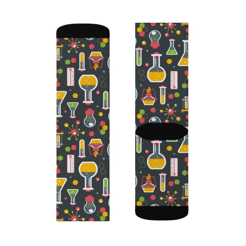 May include: A pair of black socks with a colorful pattern of beakers, test tubes, and other science-related imagery. The socks are designed for adults.