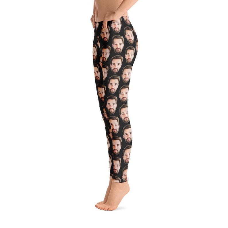May include: Black leggings featuring a repeating pattern of a man's face. The faces are in a grid-like arrangement, with a dark background. The leggings are form-fitting and reach the ankles.