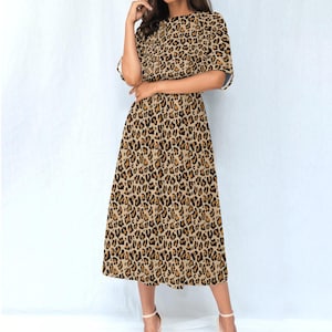 May include: A brown and black leopard print midi dress with short sleeves and a round neckline.