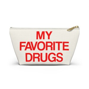 May include: White canvas zippered pouch with the text "MY FAVORITE DRUGS" in red.