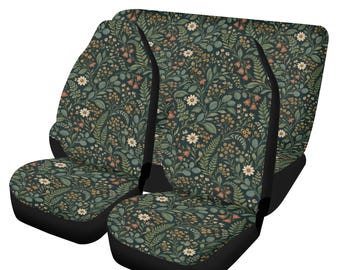 May include: A pair of car seat covers featuring a dark green background with a dense botanical pattern of white daisies, small orange bell-shaped flowers, and various green fern leaves and foliage with solid black side panels.