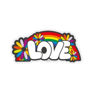 May include: A white sticker with the word "LOVE" in large, bold letters. The letters are outlined in black and have a 3D effect. The word "LOVE" is surrounded by a rainbow arc and colorful daisy flowers.