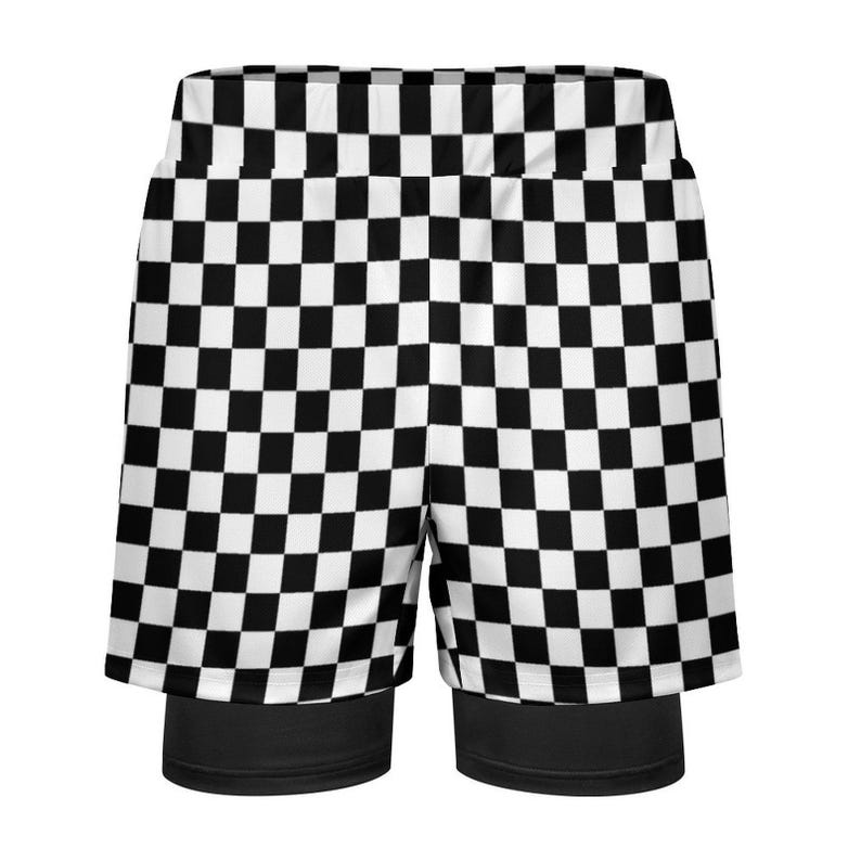 K&ouml;nnte beinhalten: Schwarz-wei&szlig; karierte Sporthose mit schwarzer Unterschicht. Die Shorts haben ein klassisches Schachbrettmuster mit abwechselnd schwarzen und wei&szlig;en Quadraten. Das Design wiederholt sich &uuml;ber die gesamte Oberfl&auml;che der Shorts.