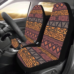 Puede incluir: Dos fundas para asientos de coche con un patrón geométrico naranja, marrón y negro. El patrón recuerda al arte tribal africano.